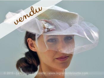Chapeau en sisal clair avec voilette en tulle.
