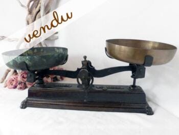 ancienne balance en fonte et ses deux plateaux en cuivre