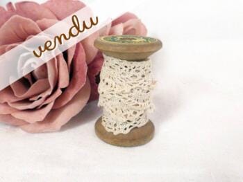 Fine dentelle écrue fait main sur petite bobine en bois