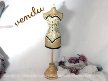 Petit mannequin sur pied, décoratif avec un corset blanc.