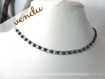 Collier ras de cou en métal argenté aux petites fleurs.