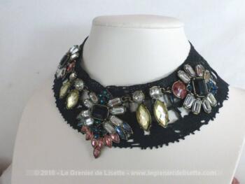 Sur un col en dentelle teinté en noir, des strass multicolores ont été cousus pour un bijoux unique.