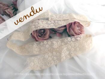 Coupon d'ancienne dentelle écrue aux dessins de fleurs et de feuilles.