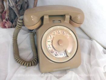 Ancien téléphone à cadran de couleur beige.