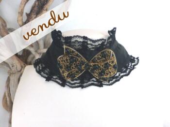 Collier ras de cou en satin et dentelle avec noeud en métal doré et ses perles noires.