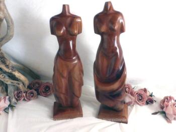 Deux statuettes différentes représentant des femmes nues, sans tête et sans bras, recouverte d'un drapé, le tout en bois massif lourd et posées sur socle.