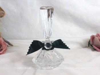 Flacon en verre avec bouchon haut en forme d'obélisque, le tout décoré d'un ruban en satin noir et d'une ancienne pampille en verre.