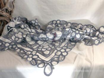 Sur-nappe satiné, teintée en gris avec mélange de tissus blanc et broderies grises. Pièce unique .