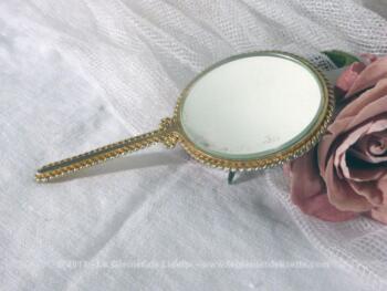 Petit miroir à main en métal doré avec au dos un écusson porcelaine.