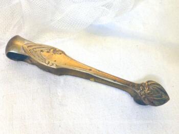 Ancienne pince à sucre en métal argenté avec dessin de fleurs.
