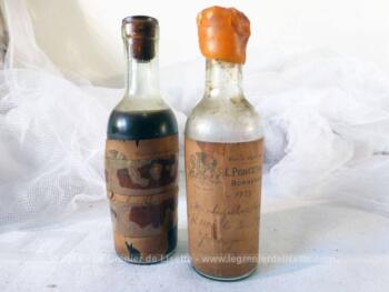 Duo de mignonnettes de vin de Bordeaux cru Monbazillac de 1929, une vide et l'autre encore avec du liquide.