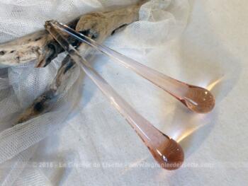 Deux longues pampilles en forme de goutte allongée en verre rose.
