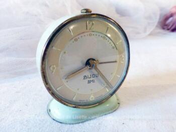 Ancien petit réveil mécanique à la forme ronde de vert pastel.