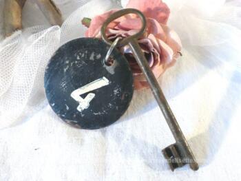 Ancienne clé  et sa plaque ronde en fonte avec le numéro 4.