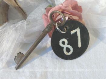 Ancienne clé  et sa plaque ronde en fonte avec le numéro 87.