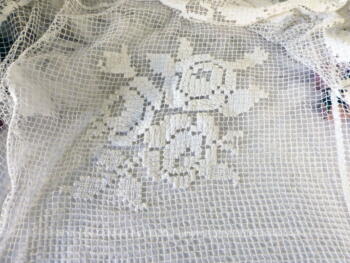 Ancienne nappe carrée de 120 x 120 cm réalisée à la main au crochet en filet avec dessin central de fleurs.