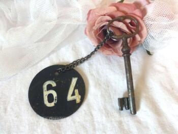 Ancienne clé  et sa plaque ronde en fonte avec le numéro 64.