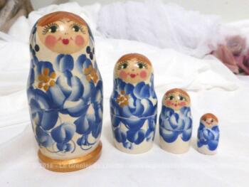 Jeu de 4 anciennes petites poupées russes signées, avec de beaux dessins de pétales bleus.