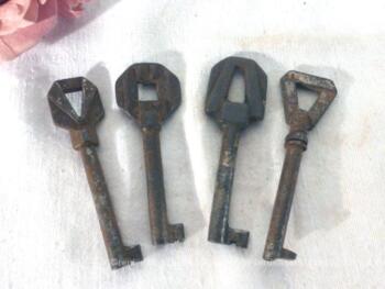 Jeu de 4 anciennes petites clés d'armoire, toutes avec des embouts aux formes géométriques différentes.