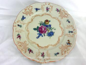 Ancienne petite assiette en porcelaine décorée de volutes dorées et de dessins de fleurs roses avec estampille au dos.