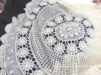 Ancienne petite nappe ronde au crochet de 95 cm de diamètre réalisée à la main au crochet avec des dessins en différentes bandes de fleurs et de vagues.