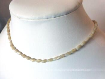 Adorable petit collier ras de cou aux perles ovales en nacre monté sur fil de nylon.