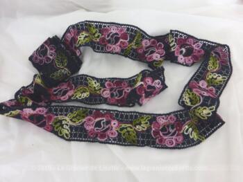 Ce coupon de dentelle noire surbrodée fils couleurs de 265 x 6 cm est décoré de fleurs multicolores noires et de larges feuilles vertes de 265 x 6 cm.