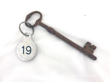 Ancienne clé et sa plaque ronde en métal gravée du numéro 19.