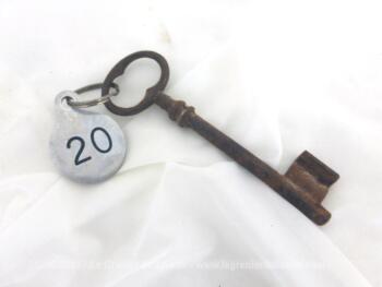Ancienne clé et sa plaque ronde en métal gravée du numéro 20.