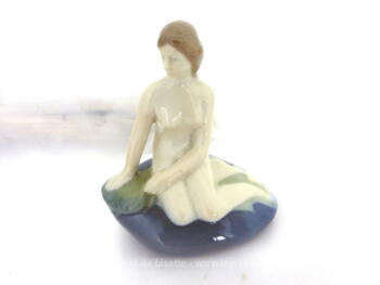 Voici une belle figurine La petite sirène d’Edward Eriksen en porcelaine, sculpture d'une grande finesse représentant une femme nue sur un rocher.