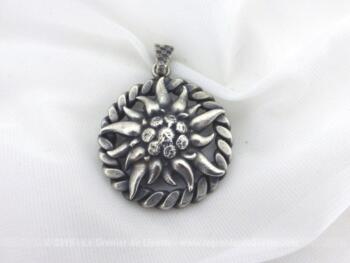 Ancienne médaille argent Edelweiss en relief de 3 cm de diamètre avec une torsade comme pourtour et avec le coeur plus ouvragé pour un effet de brillance.