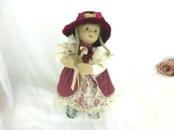 Poupée automate en porcelaine avec boite à musique en habit et chapeau velours rouge.