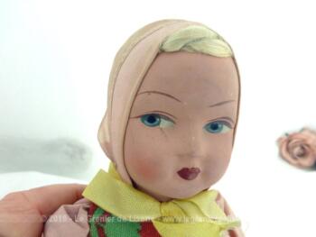 Ancienne poupée en composition et corps tissus rempli de paille dont le visage très bien dessiné nous plonge dans les années 50.