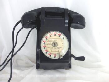 Ancien téléphone mural en bakélite des années 50/60 avec son cadran et sa petite manivelle sur le coté.