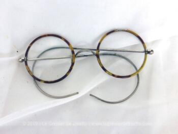 Ancienne paire de lunettes rondes imitation écaille sur une monture en métal avec ses branches très souples avec une maille en spirale.
