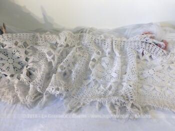 Ancien long chemin de table crochet, entièrement fait à la main, dans un beau fil de coton blanc. De forme rectangulaire aux angles arrondis, il mesure 150 x 40 cm, plus 10 cm de franges tout autour.