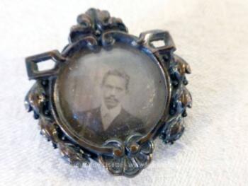 Ancien médaillon avec photo, anciennement une broche, décorée de belles volutes métal argenté avec à l'intérieur un petit cadre rond en laiton scellé et sa photo en sépia.