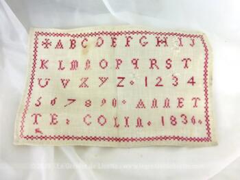 Ancien abécédaire d'écolière de 1836 de 15 x 24 cm, brodé au point de croix en fil rouge avec l'alphabet entier, tous les chiffres et signé de la jeune brodeuse assidue ANNETTE COLIN et l'année 1836.