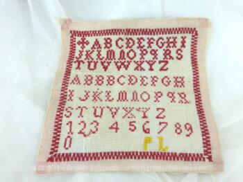 Ancien abécédaire d'écolière de 20 x 19 cm, brodé au point de croix en fil rouge avec deux modèles d'alphabets.