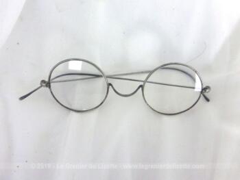 Ancienne paire de lunettes rondes métallique avec des branches fines et légères.