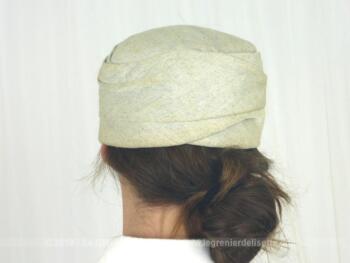 Ancien chapeau tissus avec petit noeud sur le devant avec une forme tambourin date des années 50/60. Il est en tissus chamarré beige clair et beige foncé.