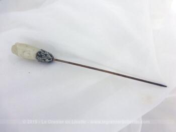 Epingle à chapeaux perle et métal argenté de 10.5 cm de long. La perle allongée en verre est ceinturée par es volutes en métal argenté. Idéal pour chapeau, pour une de vos créations ou en décoration.