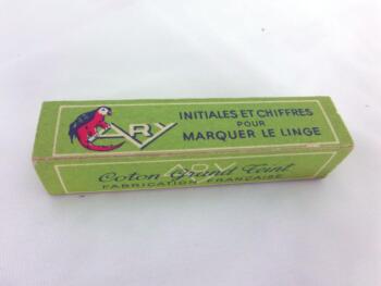 Ancien ruban avec le chiffre 179 brodé et sa boite en carton portant les inscriptions "ARY - Initiales et Chiffres pour Marquer le Linge" "Coton Grand teint. Fabrication Française".