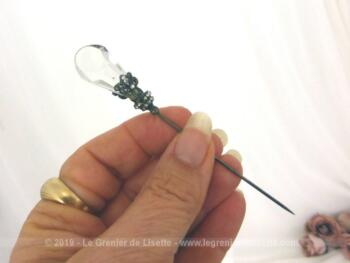 Epingle à chapeaux avec verre et métal argenté de 11 cm est composée d'une pampille en verre avec un habillage de volutes en métal argenté pour la décorer comme un bijoux.