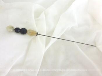 Ancienne épingle à chapeaux aux perles de 19 cm composée de différentes perles et se terminant par une petite coupelle en métal argenté ciselé.