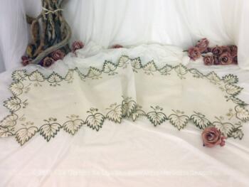 Ancien chemin de table en lin de 114 x 39 cm avec des broderies de feuilles vertes sur tout le pourtour.