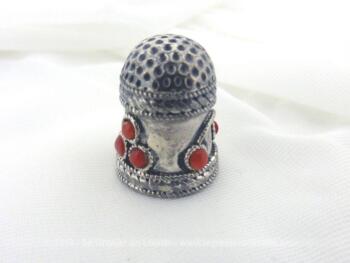 Ancien dé à coudre métal argenté, avec une forme très ouvragée dont une partie est habillée de perles rouge. En très bon état.
