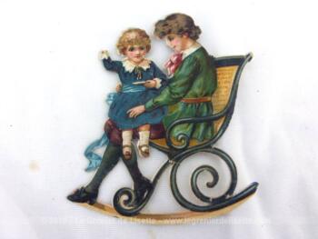 Voici une belle et très ancienne chromo découpi de 8 x 10 cm représentant une jeune femme avec son enfant sur les genoux assis sur un banc ou un rocking chair.