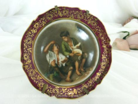 Assiette miniature à poser, en porcelaine de Limoges, représentant "Le mangeur de raisin et de melon" du peintre Bartolomé Esteban Murillo.