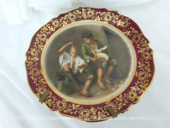 Assiette miniature à poser, en porcelaine de Limoges, représentant "Le mangeur de raisin et de melon" du peintre Bartolomé Esteban Murillo.